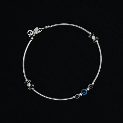 Charming silver anklet with a blue and black evil eye centerpiece, ideal for a trendy and symbolic addition to your look