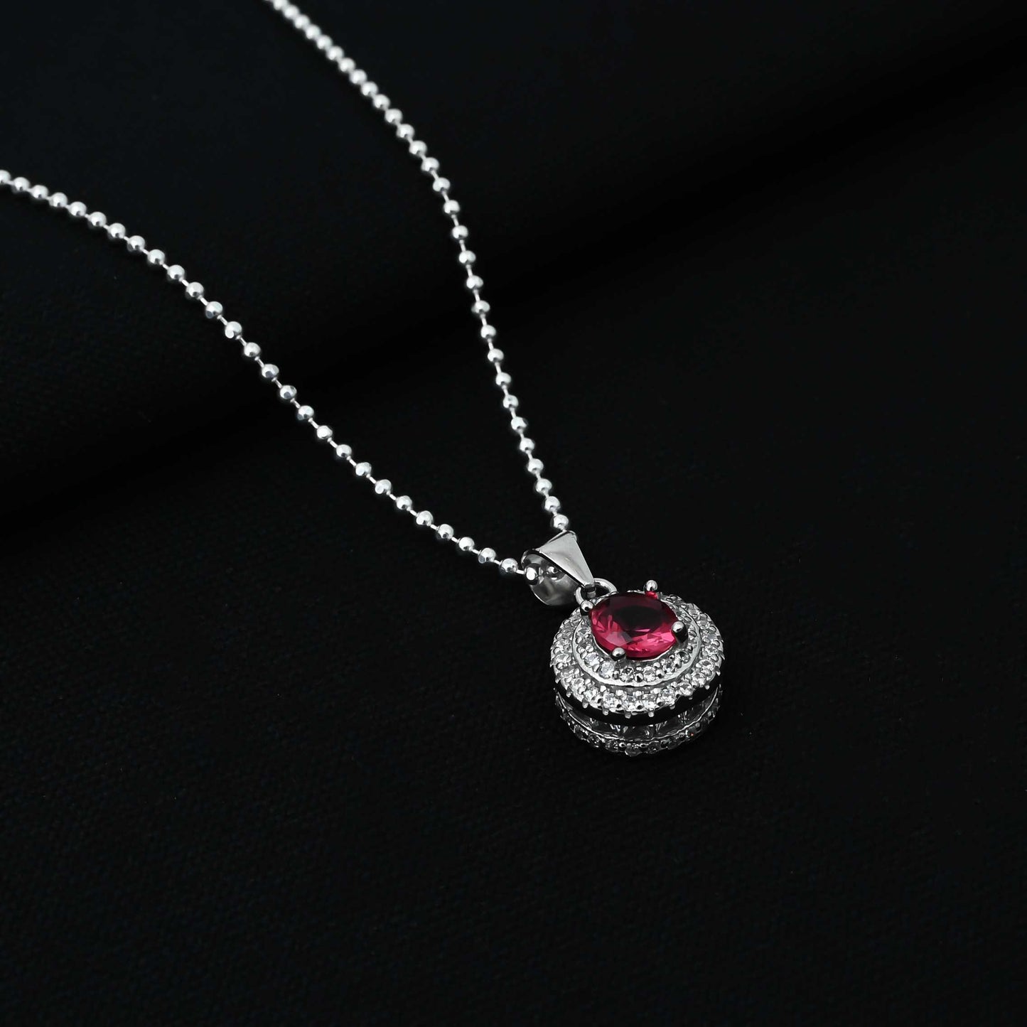 Elegant silver pendant with a central pink gemstone in a classic round design, perfect for girls