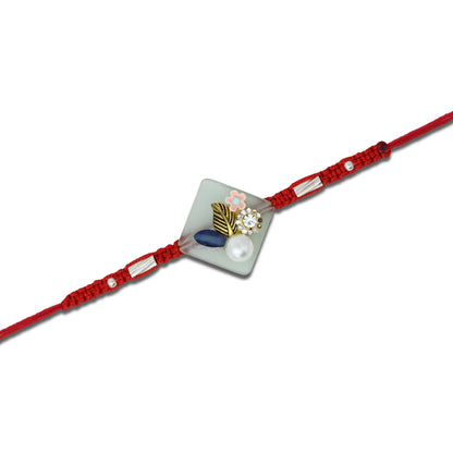 Boys' Rakhi featuring a silver flower design with pearl accents.