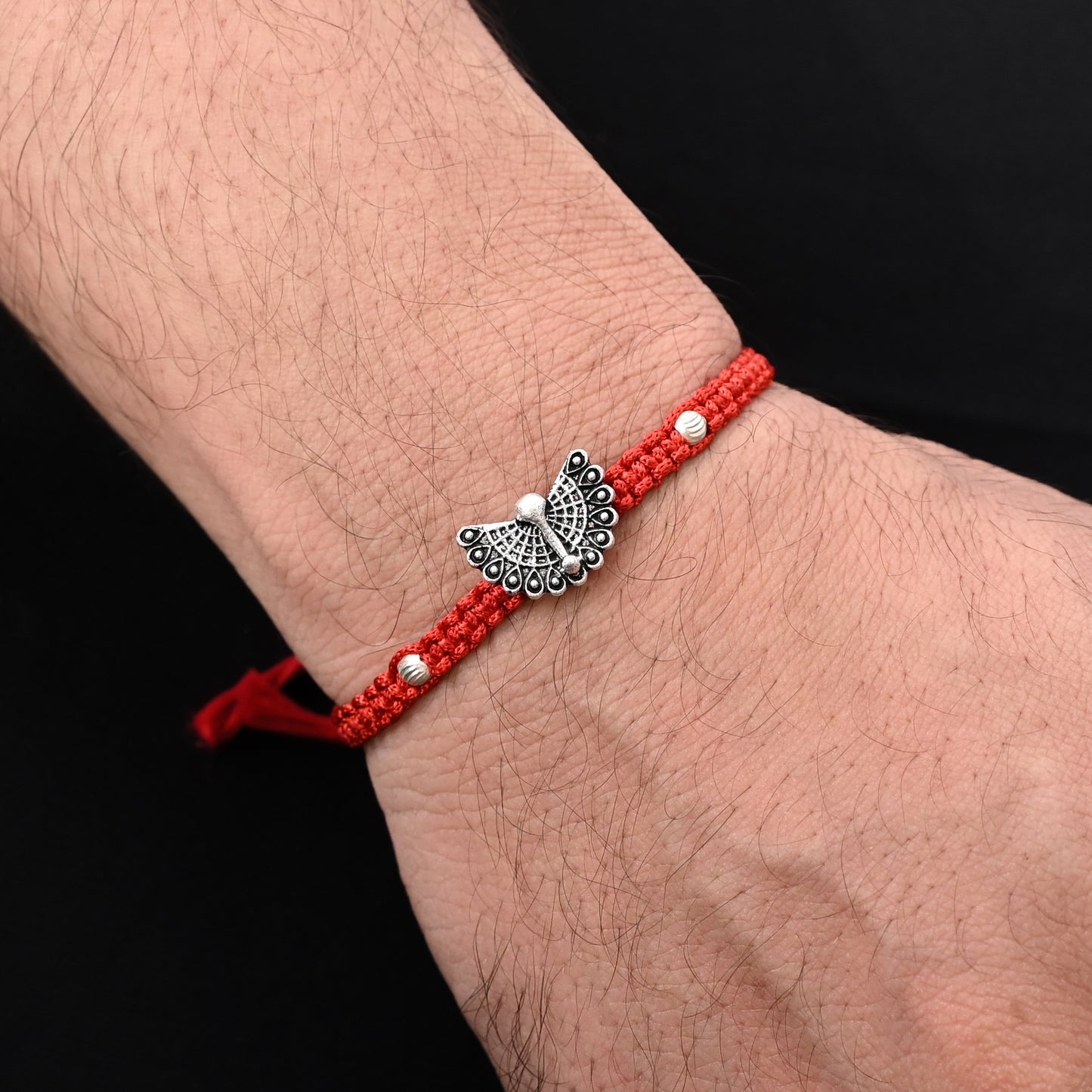Elegant Rakhi with a silver open feather peacock motif, ideal for boys