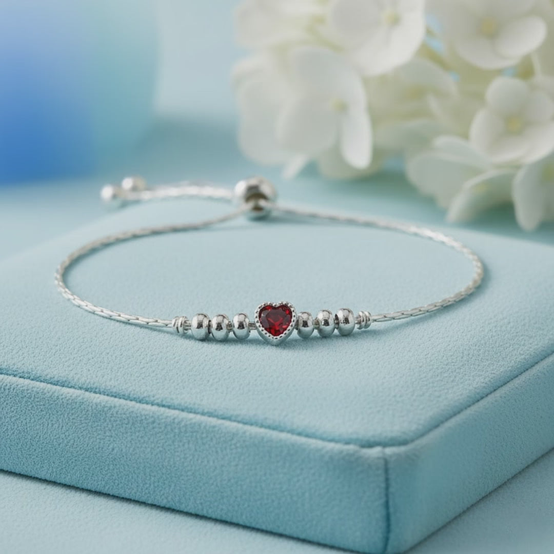 925 sterling silver adjustable bracelet with a purple heart-shaped gemstone, silver beads, and sliding clasp displayed on a light Red velvet jewelry box.